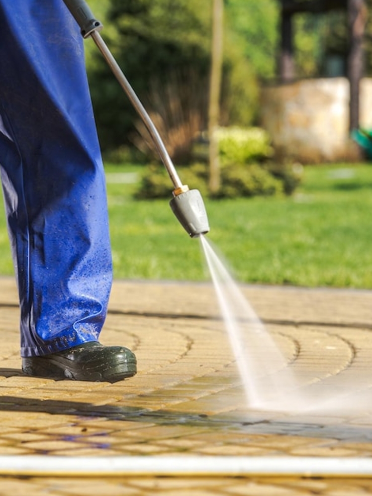 A gardener cuts the grass in a backyard.