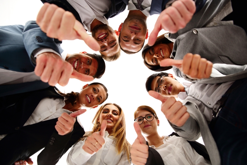 Group of business people standing in circle, with thumbs up Group of business people standing in circle, with thumbs up